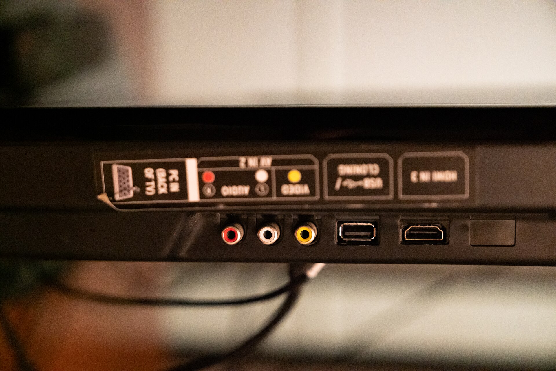 Painel traseiro de um decodificador de TV a cabo com entradas RCA, USB, HDMI e coaxial lado a lado