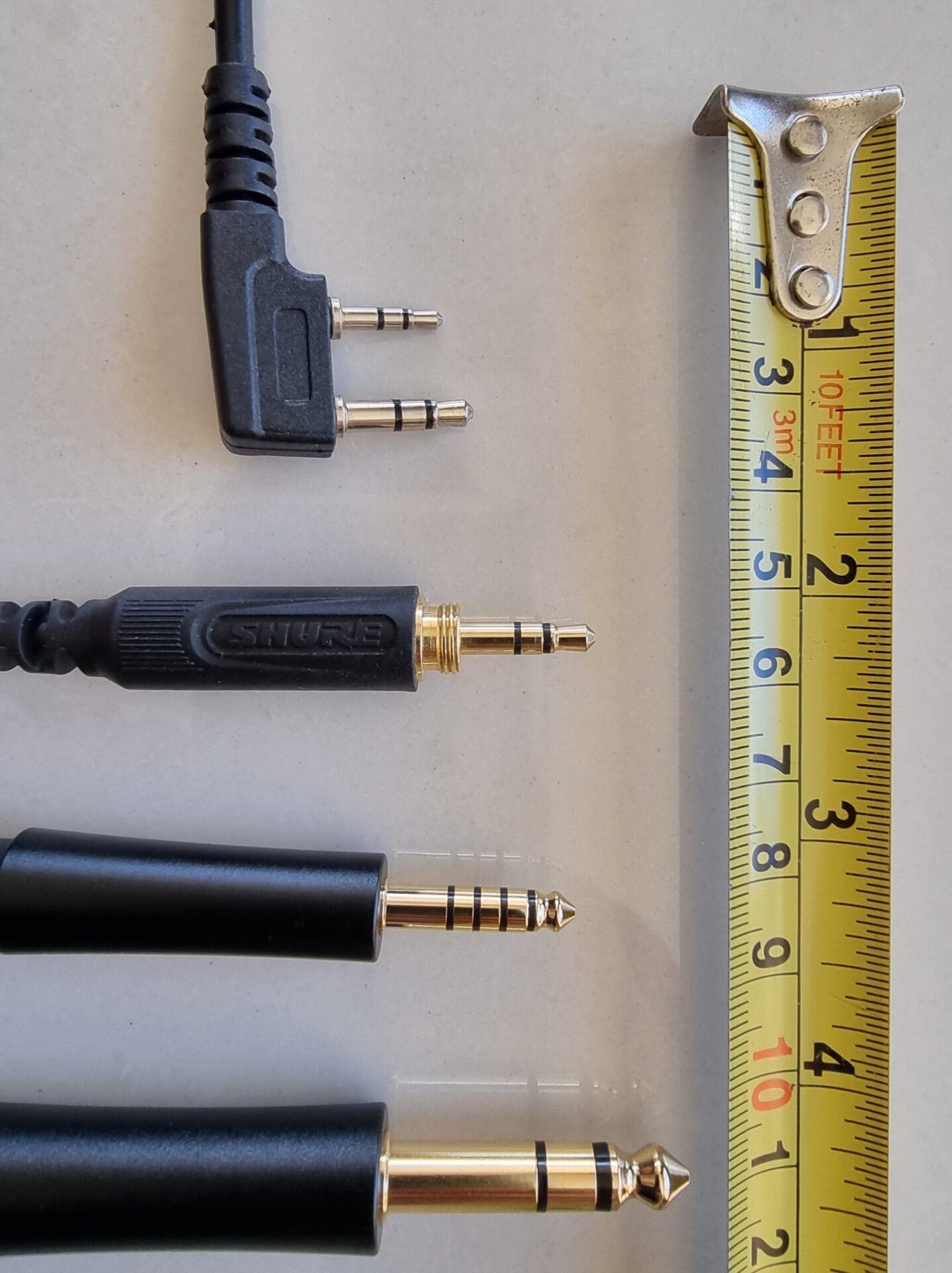 Plugues de áudio de 6,35 mm, 3,5 mm e 2,5 mm lado a lado mostrando os anéis de contato